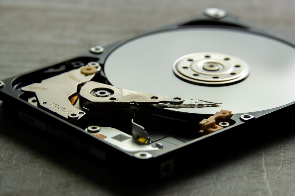 Detailed view of an open hard drive, showcasing the disk platter and actuator arm.